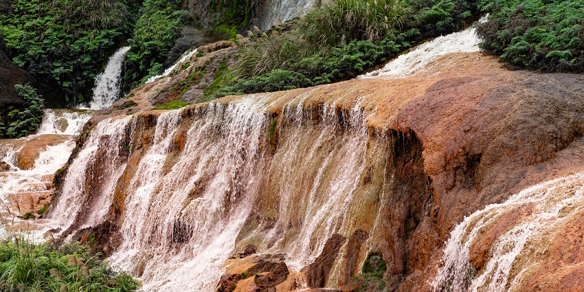 A forested mountain landscape with rocky cliffs that hint at a hidden Chinglong Waterfall.