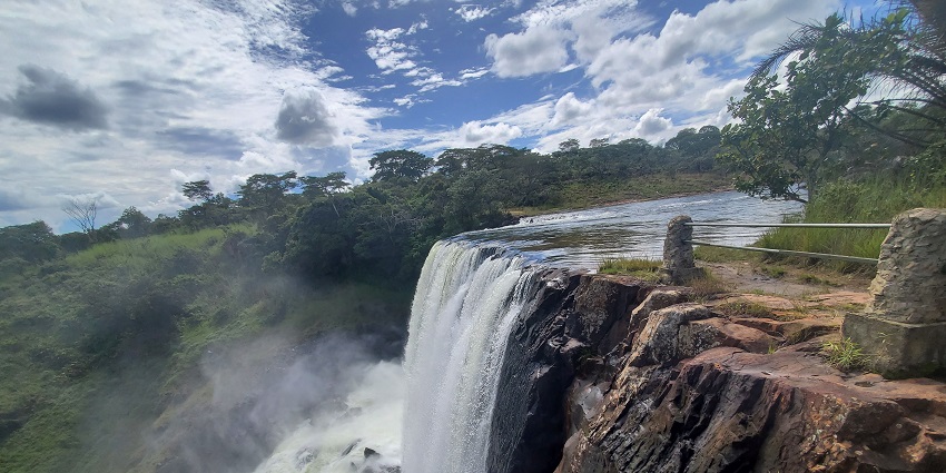Thunderous falls plunge from rocky cliffs into misty depths under a dramatic sky.