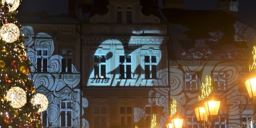 Christmas lights and festive projections illuminate buildings during celebrations.