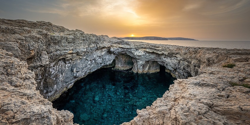 An image of Coral Lagoon with crystal waters and rocky surroundings at one of the Malta caves.