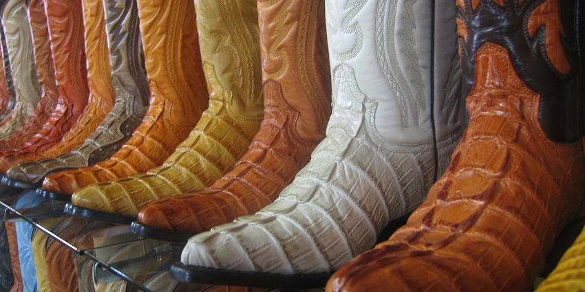 Colorful display of cowboy boots in a market stall, showcasing popular things to buy in US.