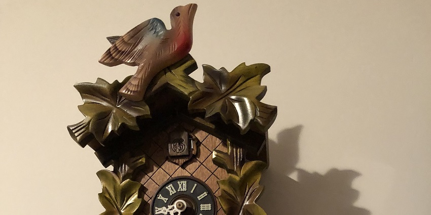An image showing a view of a Swiss cuckoo clock hanging on a wooden wall.