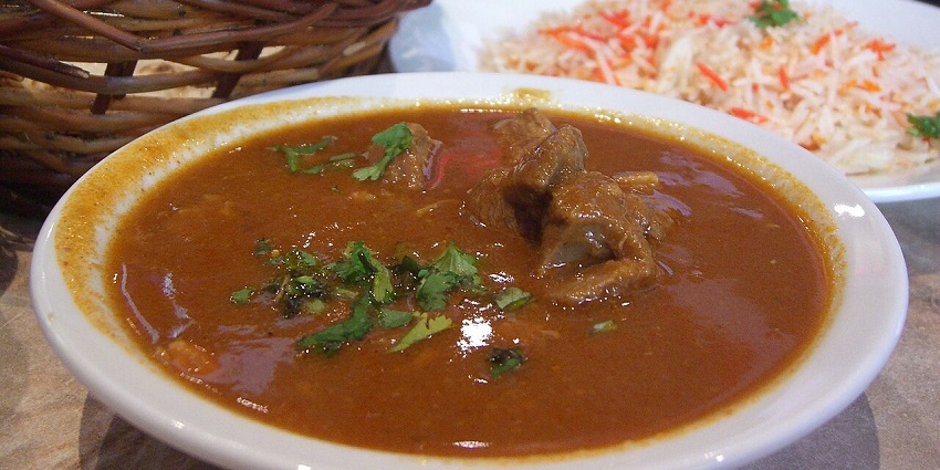 Image of a plate of tender Curry Goat served with rice and peas, the best food in Jamaica.