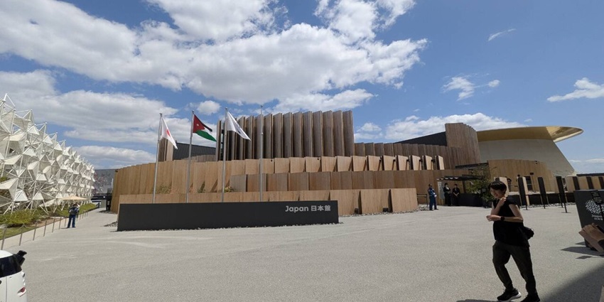 Japan pavilion in World Expo 2025 with multiple flags, signages and people walking around