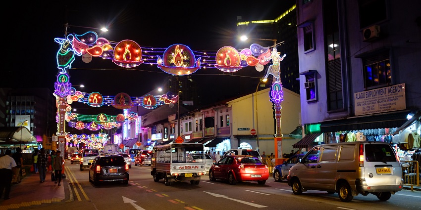 Colourful lights and decor beside high-rise buildings during a festive night celebration.