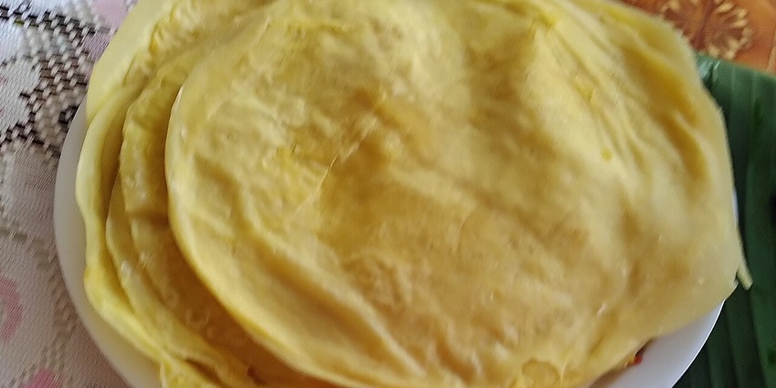A plate of dholl puri, a traditional Indian flatbread stuffed with yellow split peas, served with chutney.