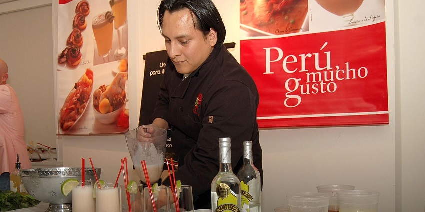 Pisco Sour cocktails at a Peruvian festival booth celebrating National Pisco Sour Day traditions.