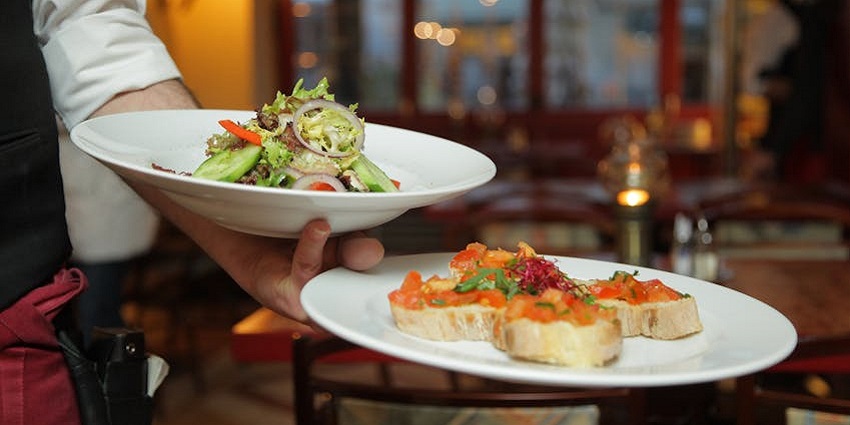 A family being served tasty dishes by a waiter at Seasons 52, a top restaurant in Buford.