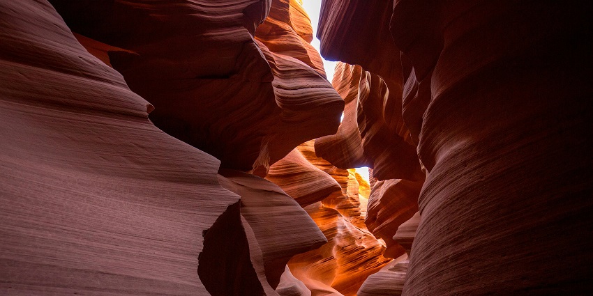Sunlight piercing through orange canyon walls, nature’s version of things to do in Arizona.
