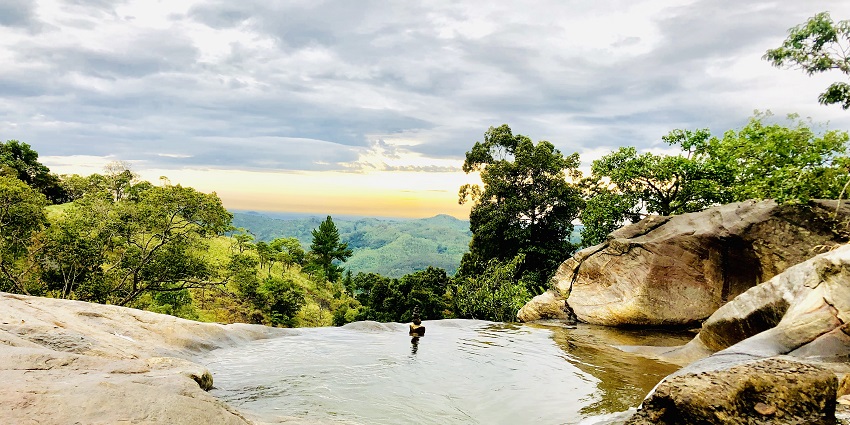 Cascading waters of Diyaluma Falls flowing down rocky cliffs in the Sri Lankan highlands.