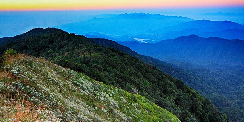 The Doi Pha Hom Pok displays all its hues of green, blue, white, and orange during sunset.