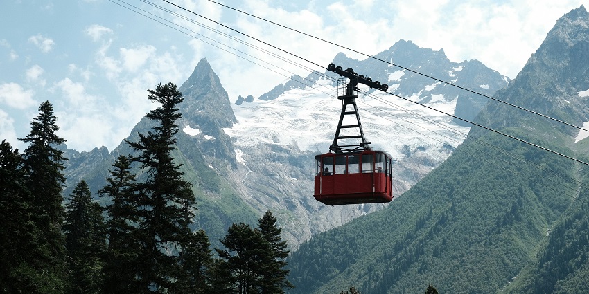 Gondola cars with a backdrop of the magnificent Dombay Mountains in Southern Russia.