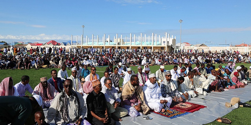 People in traditional attire celebrate Eid al-Fitr outdoors during festivals in Egypt.