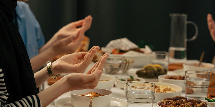 Image of people praying before breaking their fast during the Ramadan celebration meal.