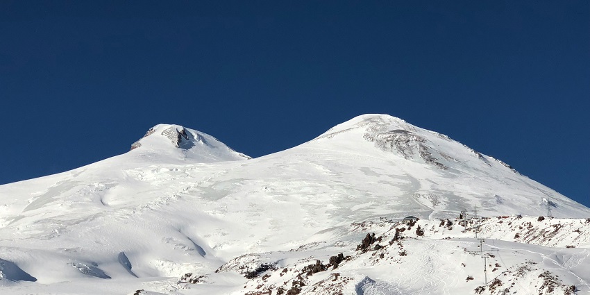 A scenic road leads towards the magnificent Mount Elbrus in the Western Caucasus Mountain.