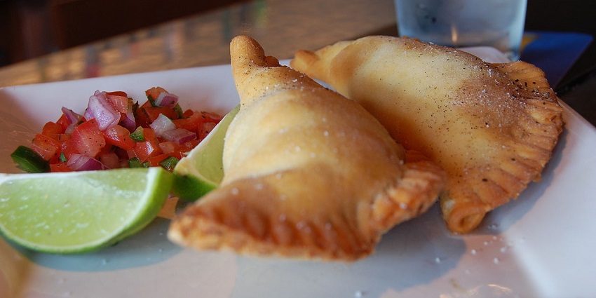 An image of Chilean empanadas filled with meat and baked to a golden crust.