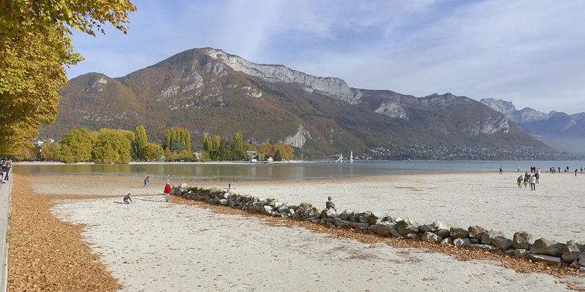 Families walking along Le Pâquier with the lake in view, showcasing relaxed things to see in Annecy, France.