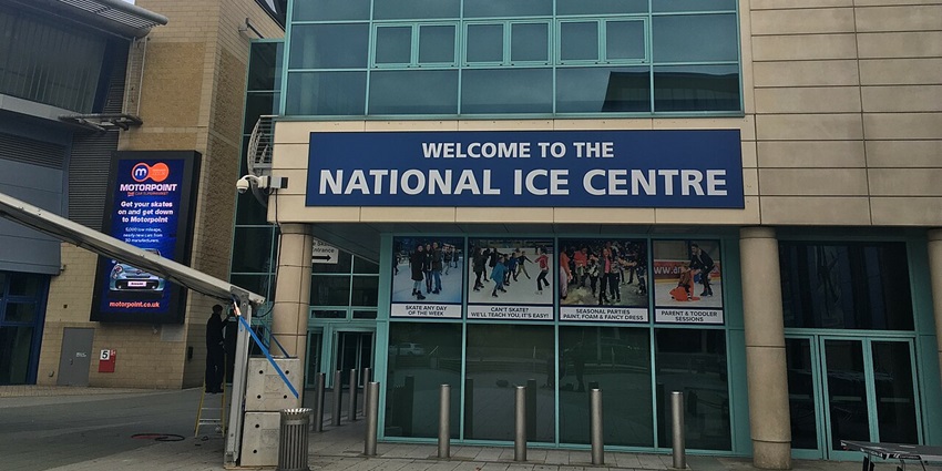 Front view of the National Ice Centre with modern glass architecture.