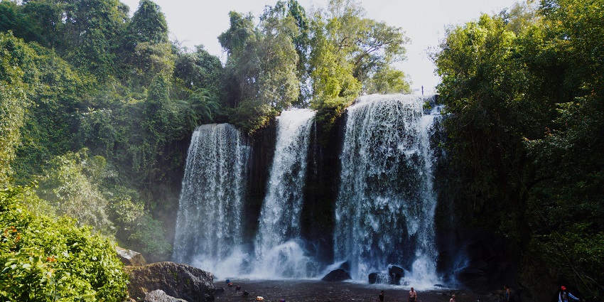 Image of a stunning waterfall surrounded by rocks and lush green forest