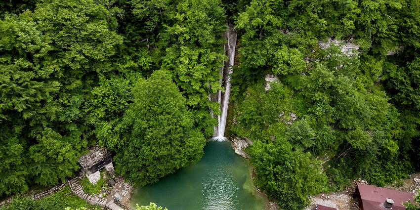 Waterfall flowing into the waterbody and a wooden bridge - one of the waterfalls in Turkey.