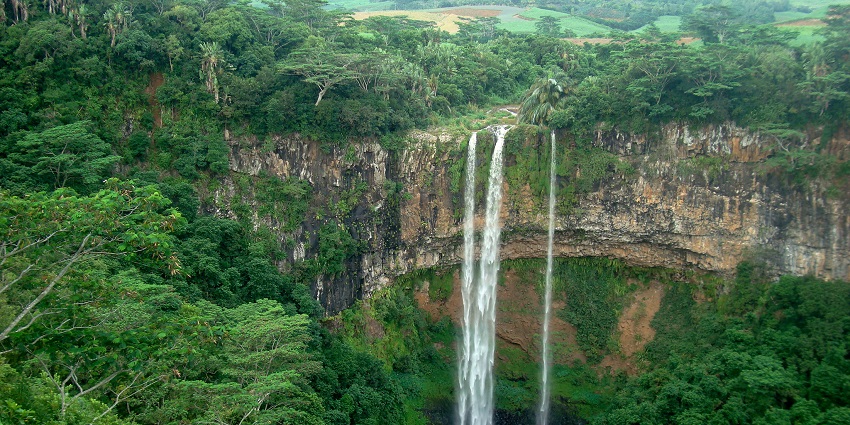 Mauritius waterfall with shining stones, water flowing through them, and lush surroundings