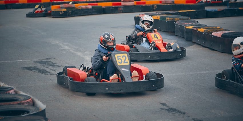 Tourists enjoying go karting at an indoor centre, a playful thing to do in Buford, GA.