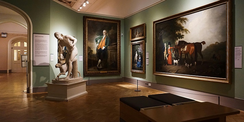 People glancing at wall paintings at an Art Museum, getting a glimpse rich heritage and culture