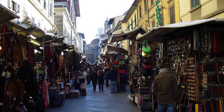 Locals and tourists shopping at San Lorenzo Market, one of the fun things to do in Florence in June.