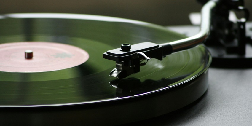 A well-lit store displays vinyl records with colourful album covers in wooden crates.