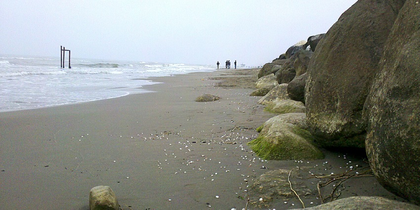 View of a quiet beach in Nowshahr, Mazandaran, with large rocks and gentle sea waves