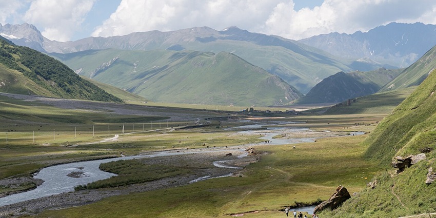 Colourful mineral springs and rocky valley plains under a bright sky, unique natural things to do in Kazbegi.