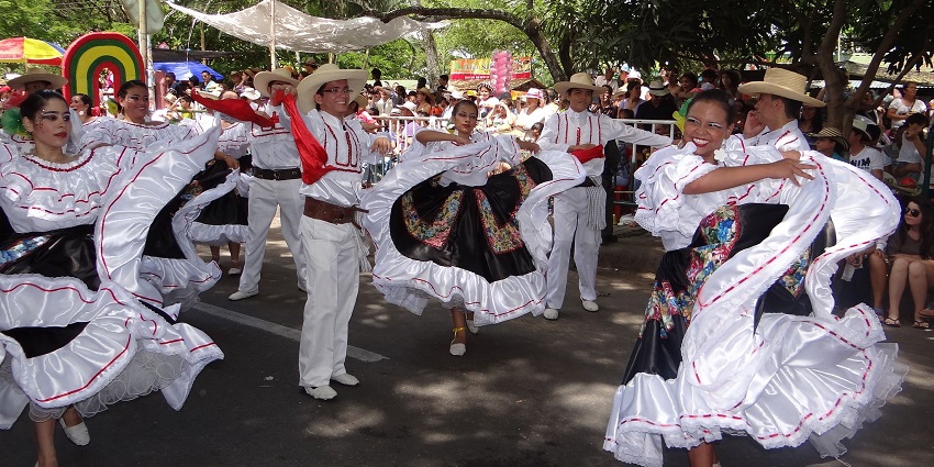 Street dancers and colorful floats parade through San Pedro Sula during Feria Juniana.