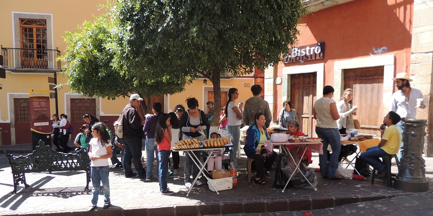 People enjoying a sunny day in a vibrant street, at one of the festivals in Mexico.