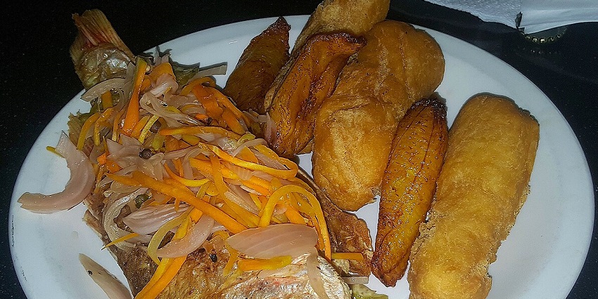 An image of a Golden and crispy Jamaican Festival served beside fried fish.