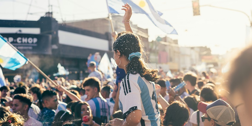 A crowd of people standing around each other, celebrating at a festival in Argentina.