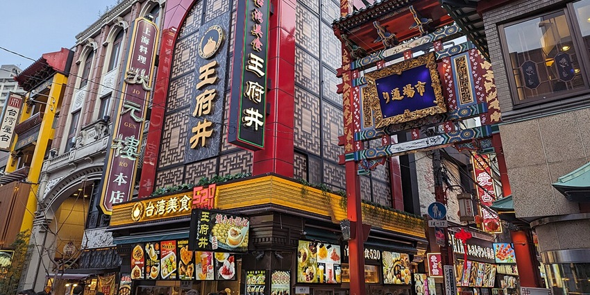 Colourful streets in Yokohama's Chinatown with vibrant signs, lanterns, shops, and bustling crowds of visitors.