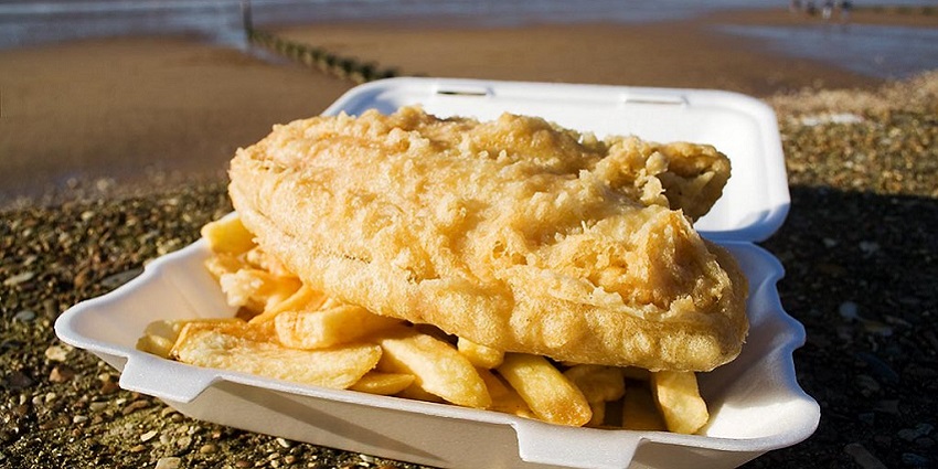 Image of a serving of golden fish and chips with tartar sauce, a famous street food in London.