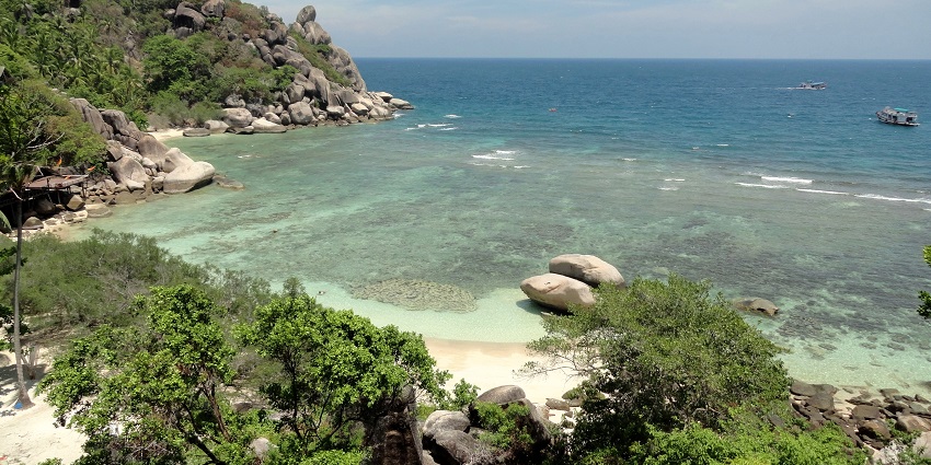 Stunning views of Freedom Beach, Koh Tao surrounded by lush greenery and rocks