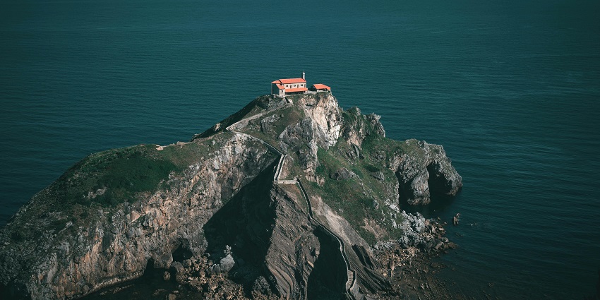 View of an island similar to Game Cock Islet, showcasing its chapel atop rocky islets