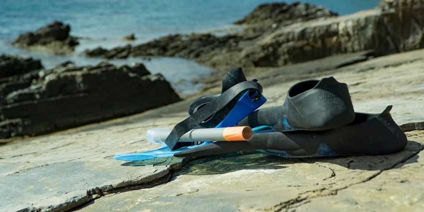 Snorkellers swimming with tropical fish around coral reefs at Pigeon Island Marine Park.