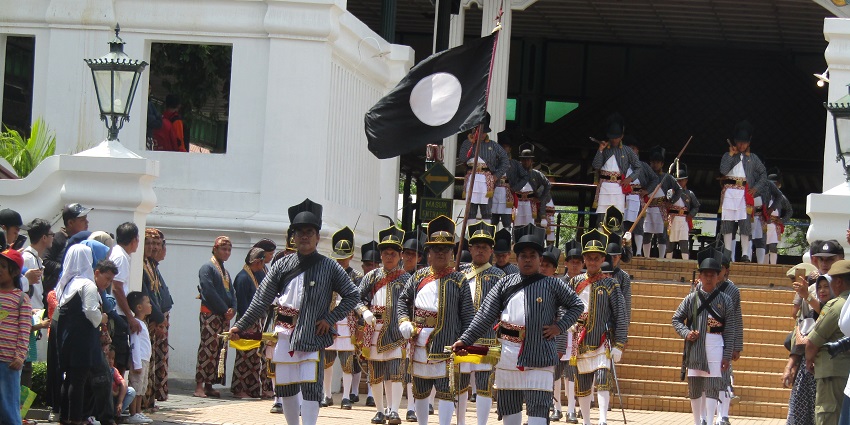 People wearing black costumes parading from the palace and celebrating Grebeg Maulud Festival.