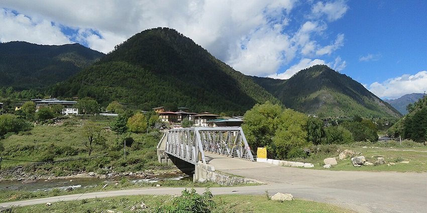 A wide shot of Haa Valley showcasing grassy open land, homes, and surrounding hills.