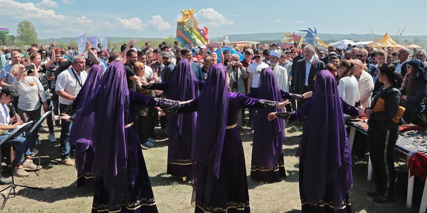 At the Hıdırellez Festival, women in purple, traditional attire, form a circle and dance