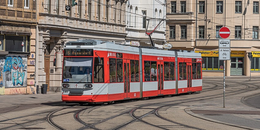 People outside the G: Link tram at the station under the serene weather and grey sky
