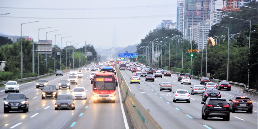 Gyeongbu Expressway with several cars and buses on the lanes with headlights on