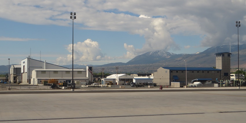 Reno-Tahoe International Airport with a runway, airport buildings, tall lights and mountains