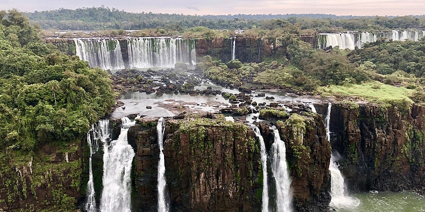 Magnificent view of Iguazú Falls with multiple streams cascading into a greenish pool.