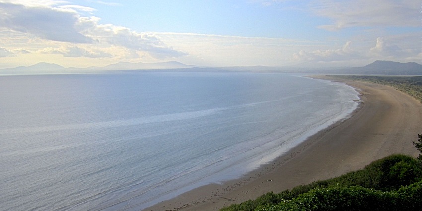 Things to do in Wales include paddling alongside seals and dolphins in this serene bay rich with marine life.