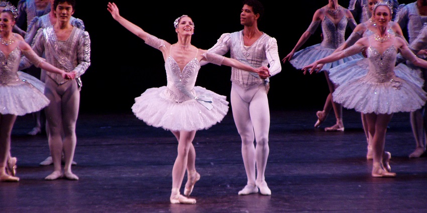 The stage performance of ballet artists with a couple in the centre with other dancers