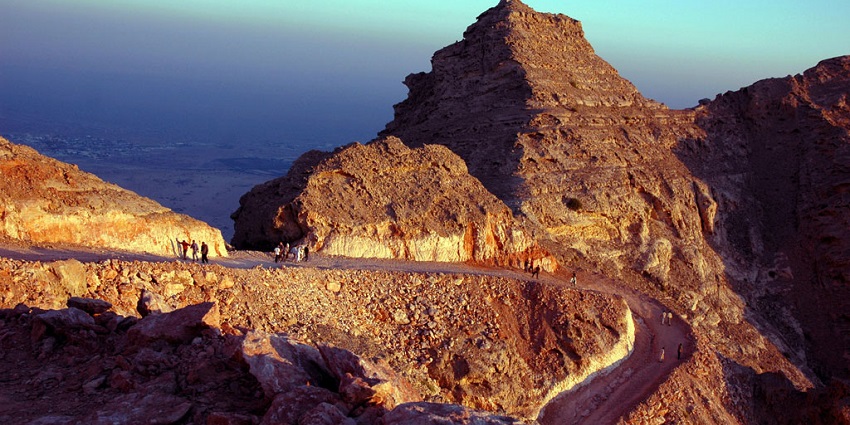 The barren mountainous terrain of the Jebel Hafeet in Al Ain with a few tourists exploring its hidden treasures.